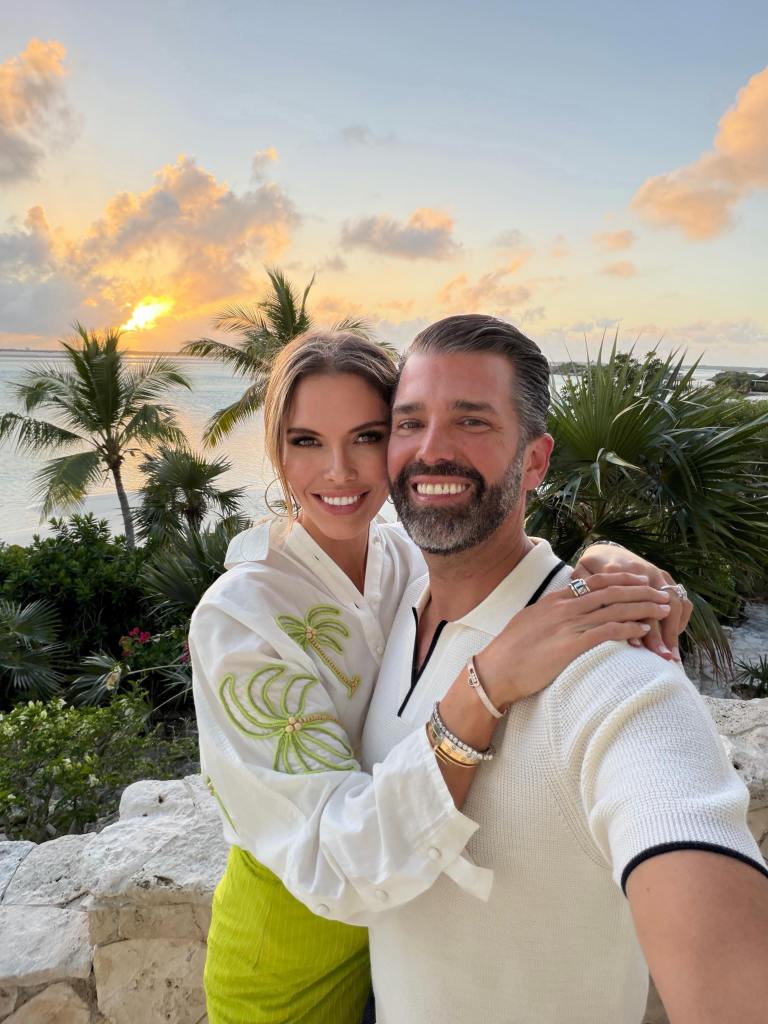 Bettina Anderson and Donald Trump Jr. posing for a selfie in front of a tropical sunset.