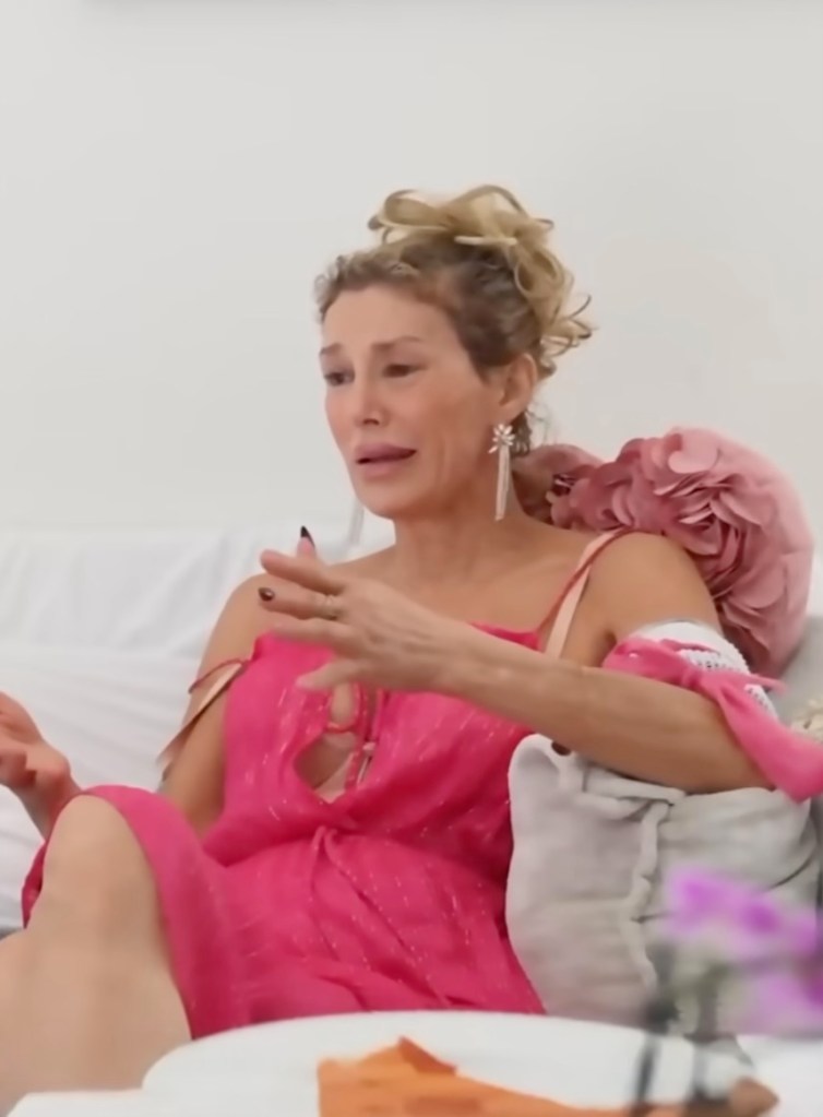 Brandi Glanville crying and speaking with her hands in a pink dress.