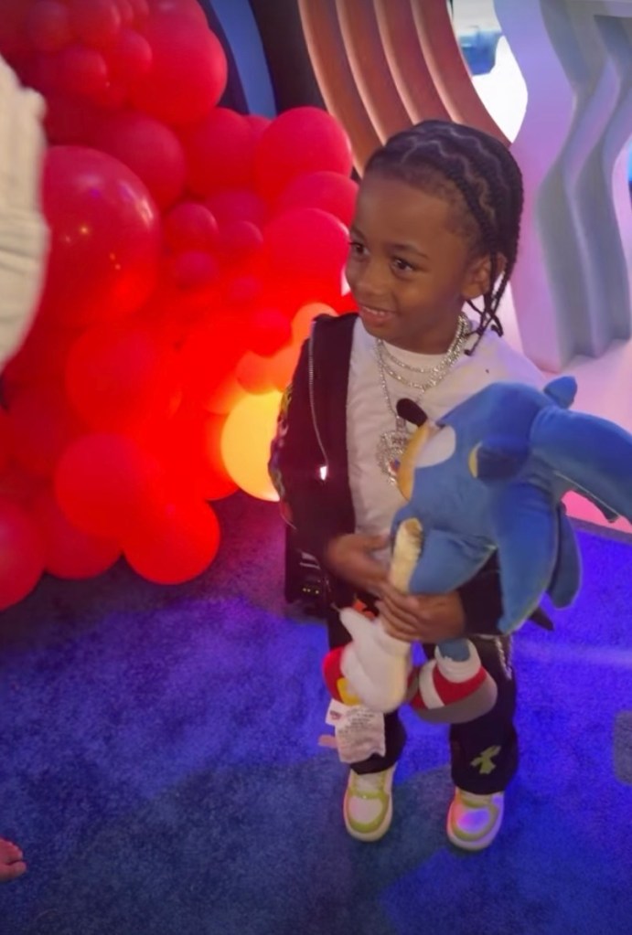 Cardi B's son, Wave Set, holding a Sonic the Hedgehog plush toy at his birthday party.