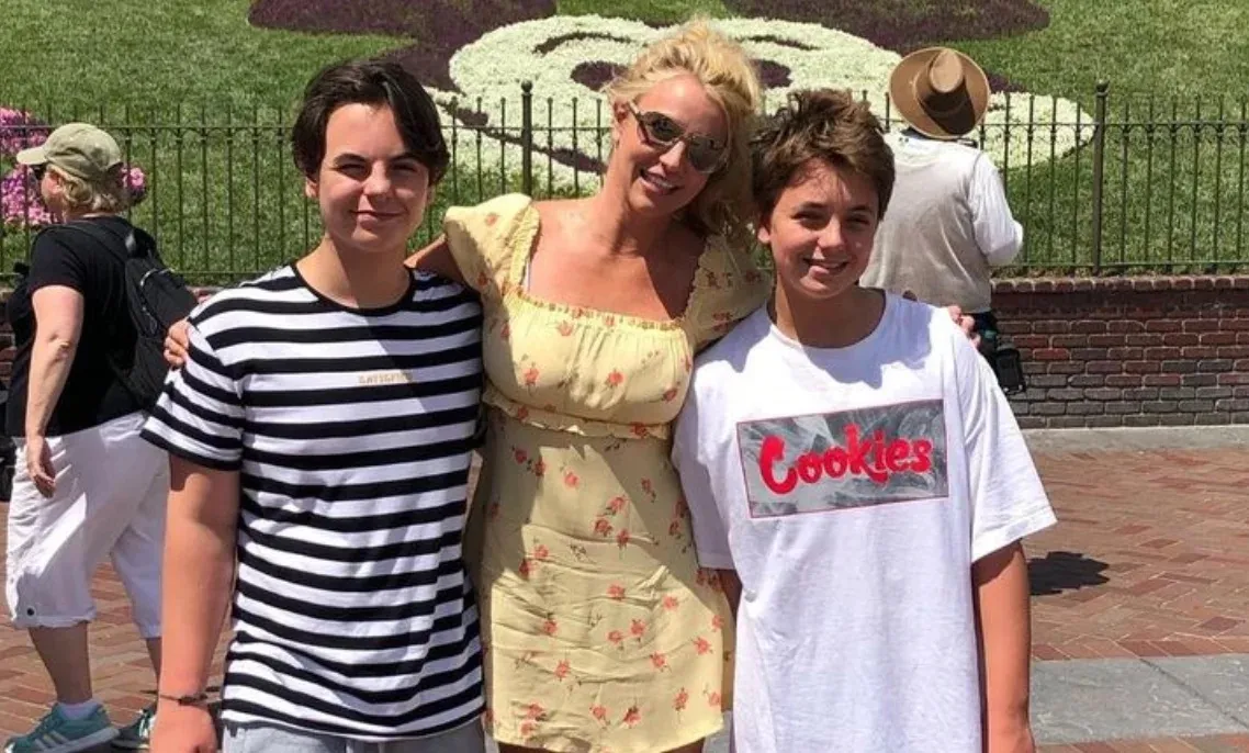 Britney Spears poses between her two sons, Sean Preston and Jayden James, outdoors.