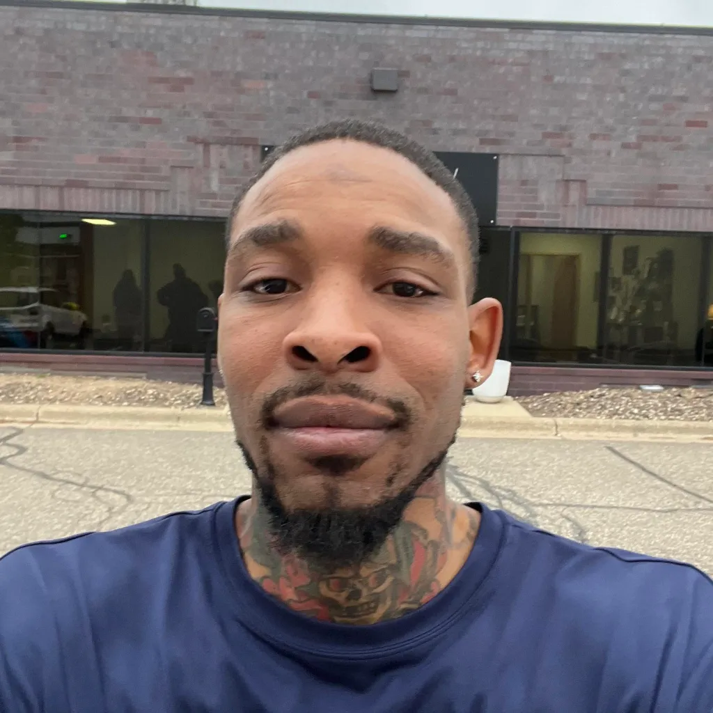 Carlton Johnson, a suspect in a Minneapolis shooting, wearing a navy blue shirt.