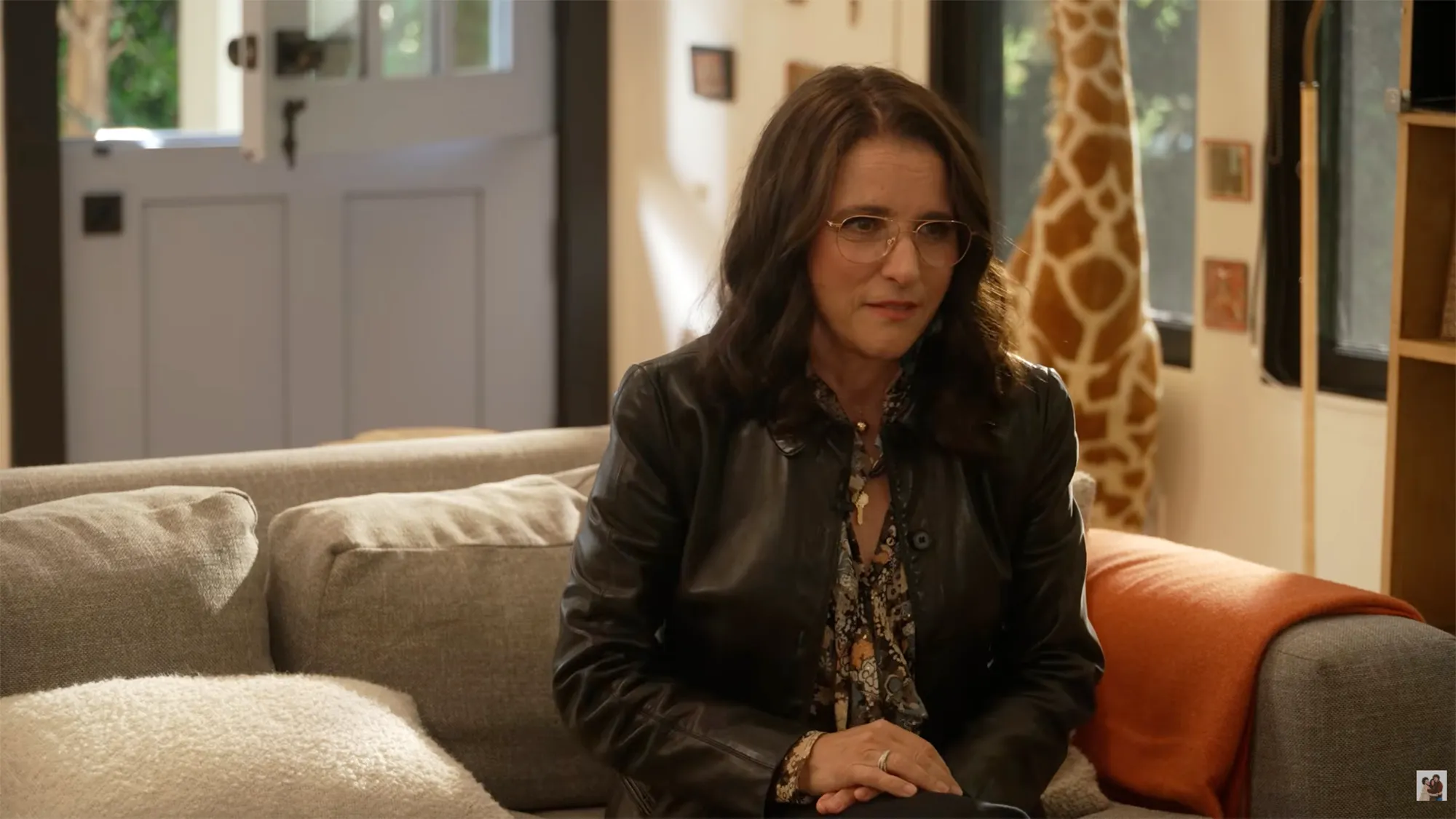 Julia Louis-Dreyfus sitting on a couch.