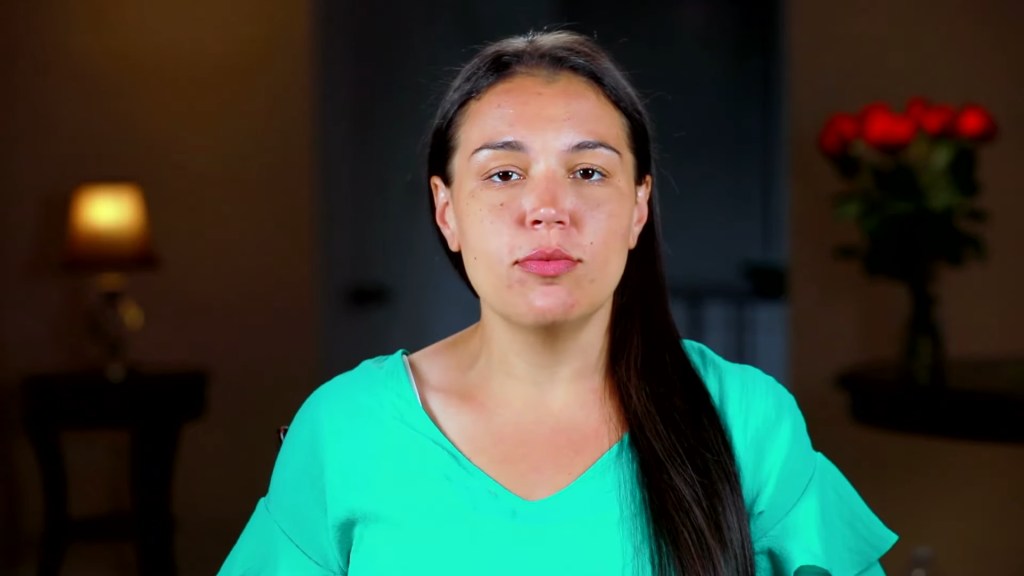 Amber Eggers in a teal V-neck top.