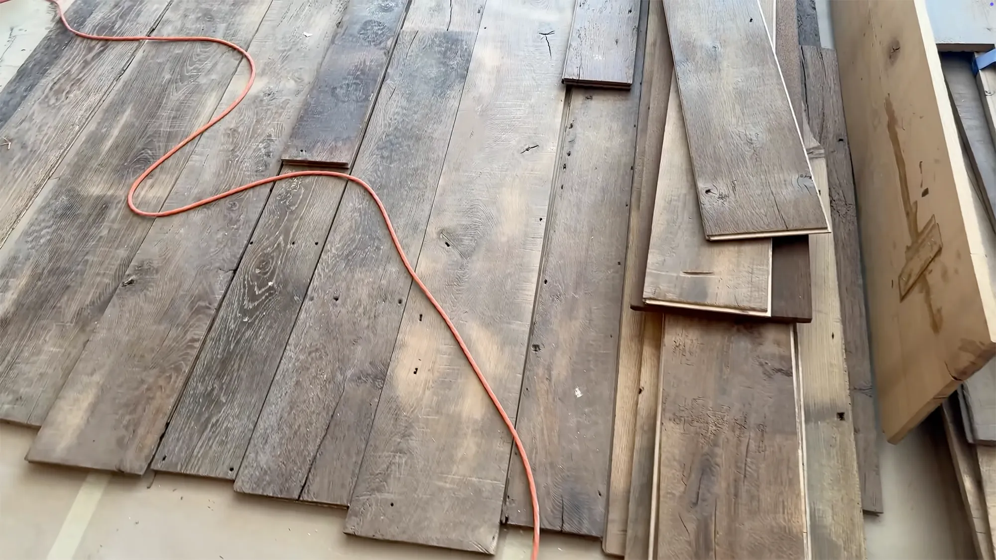 Hardwood flooring under construction with an orange extension cord.
