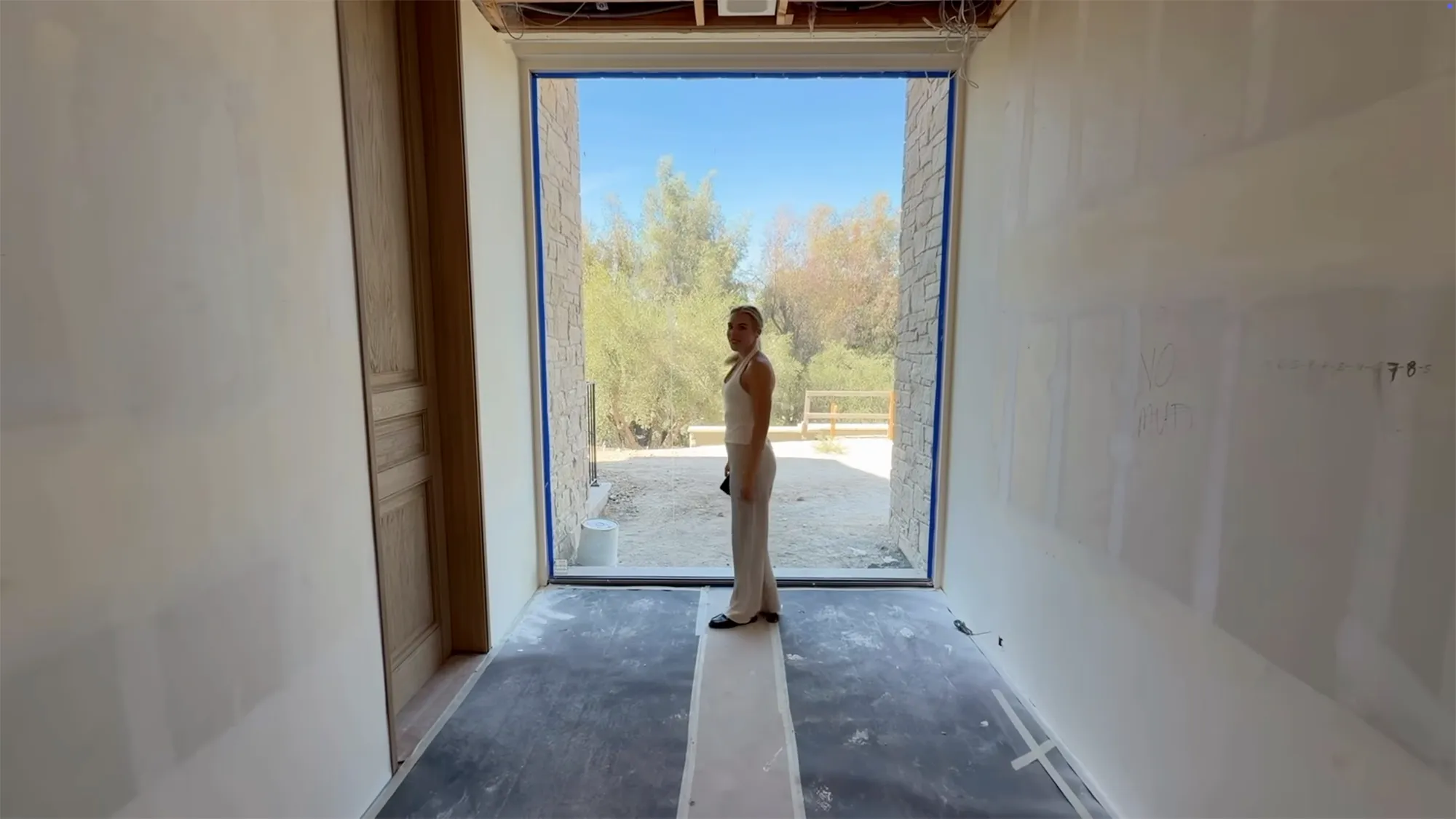 Kylie Jenner standing in a new home under construction.