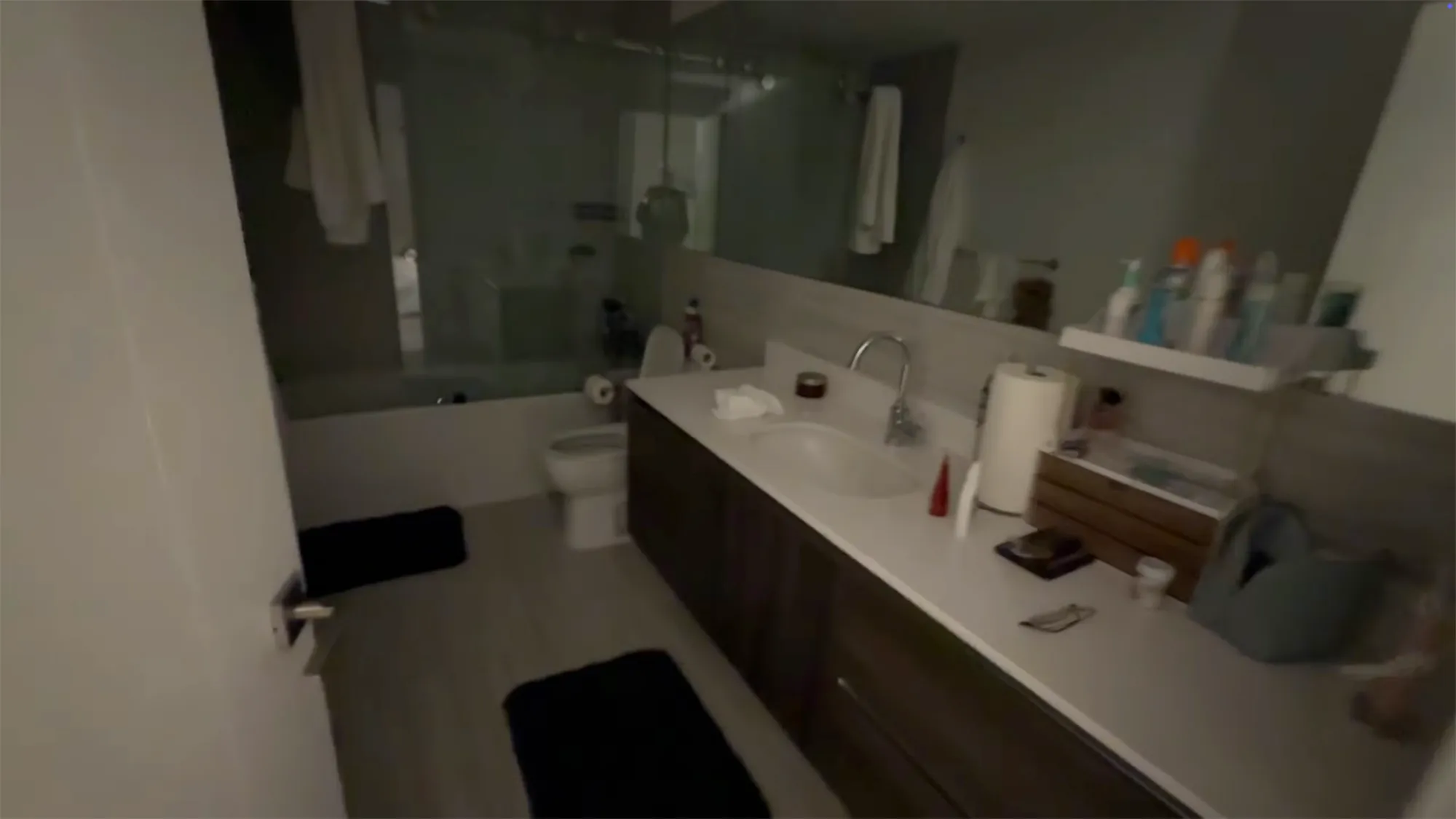 A college apartment bathroom with a toilet, bathtub, and large vanity.