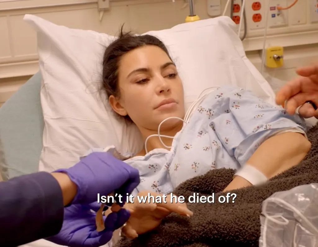 Kim Kardashian in a hospital bed with a medical professional taking a blood sample.