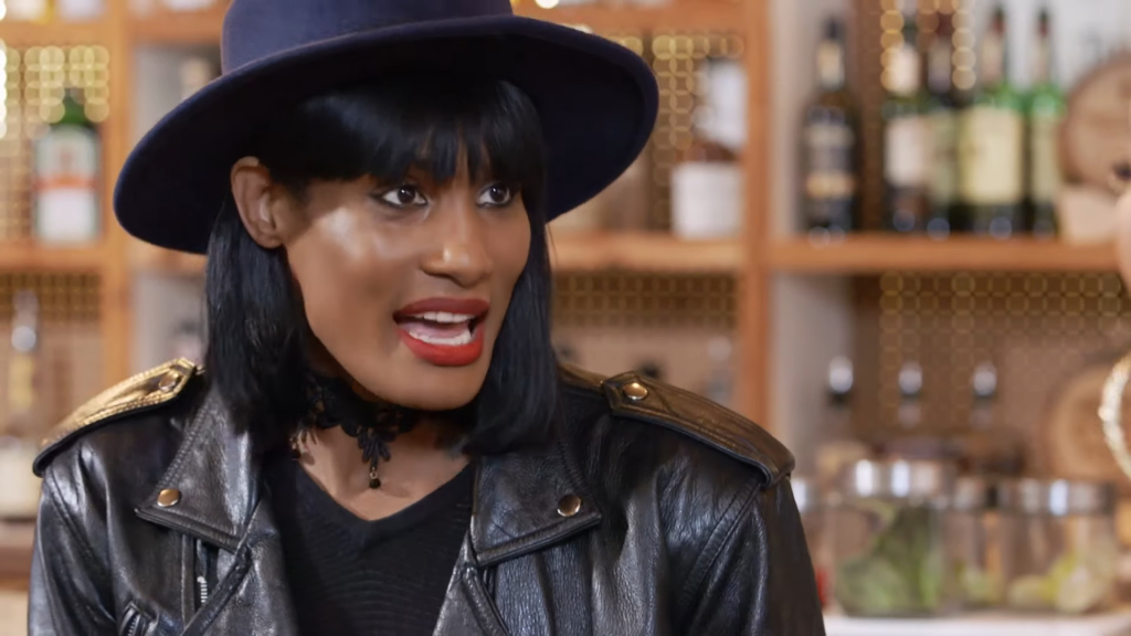 Shay Johnson in a black leather jacket and a dark blue hat.