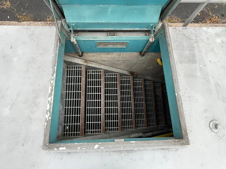 Staircase of metal grates descending into a bunker.