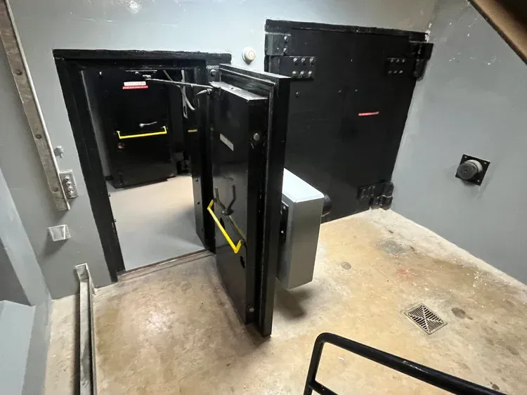 A series of open and closed vault-like bunker doors.