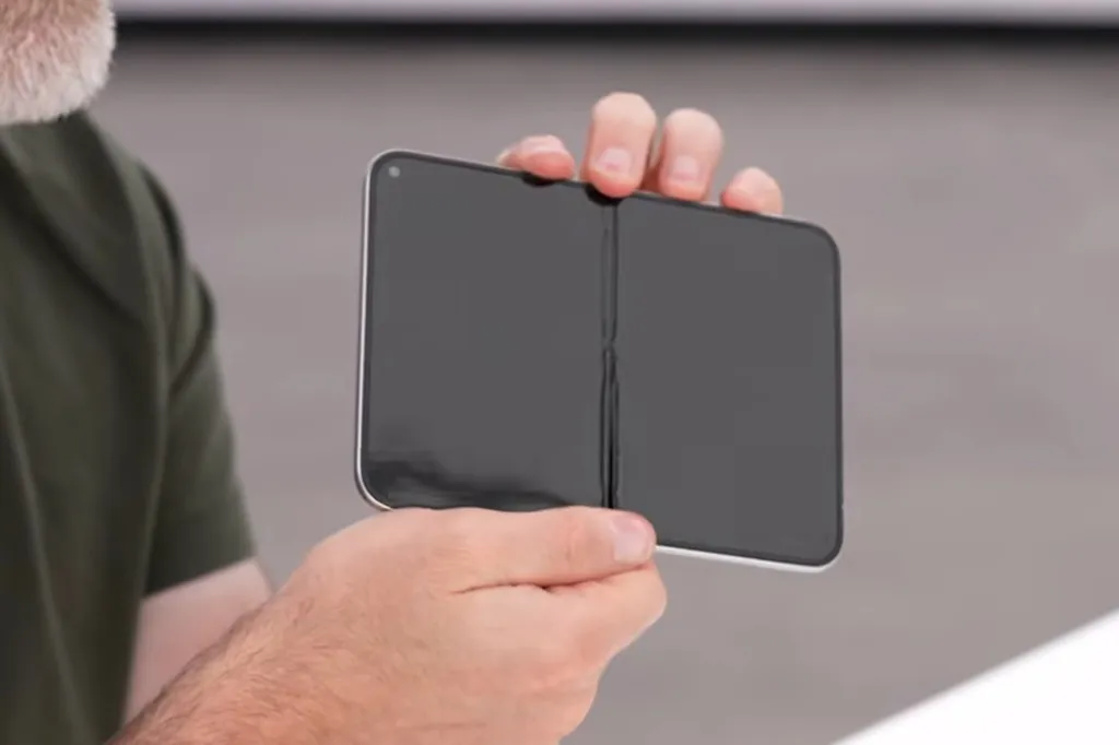 A person holding a foldable iPhone Ultra prototype with a visible crease in the middle of the screen.