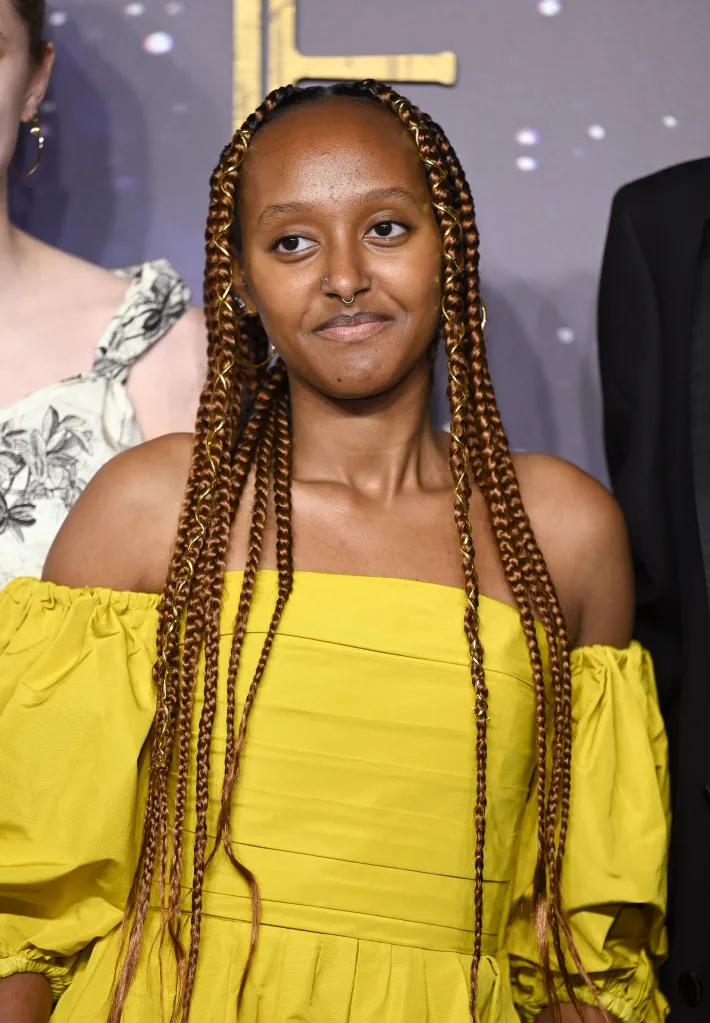 Zahara Jolie-Pitt in a yellow off-the-shoulder gown with long braided hair and a nose ring.