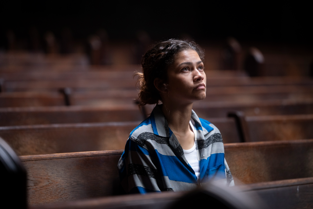 Zendaya as Rue Bennett from Euphoria, sitting in a church pew and looking up.