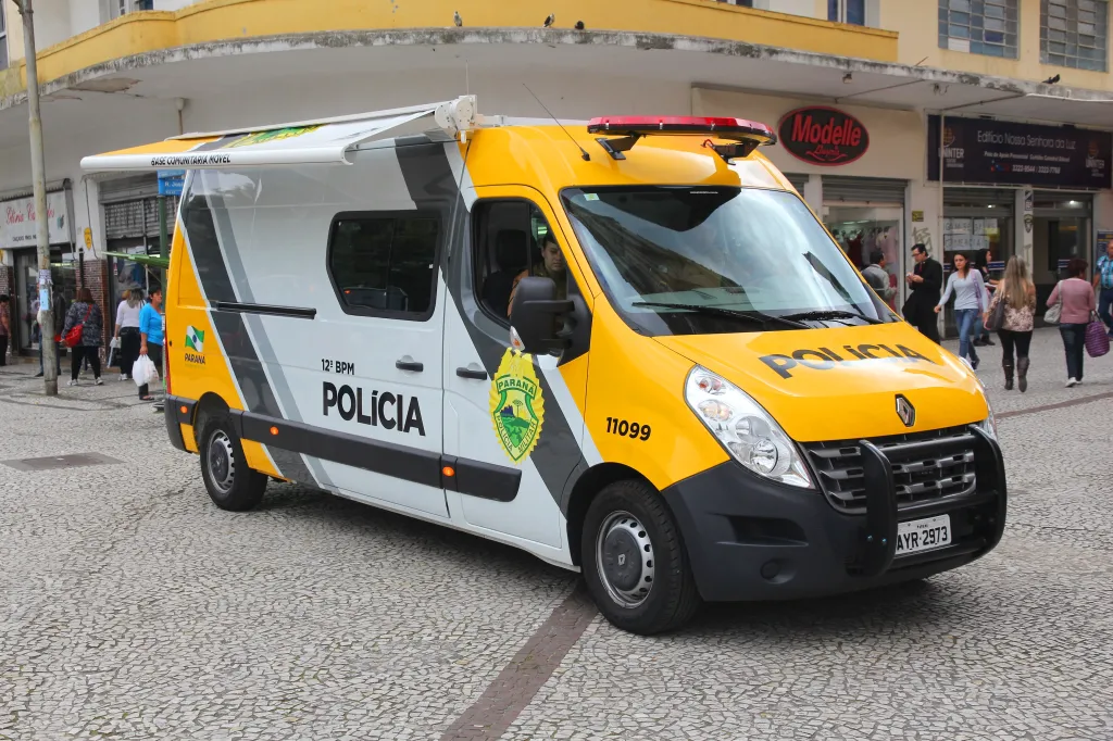 A military police van parked on a cobblestone street in Curitiba, Brazil.