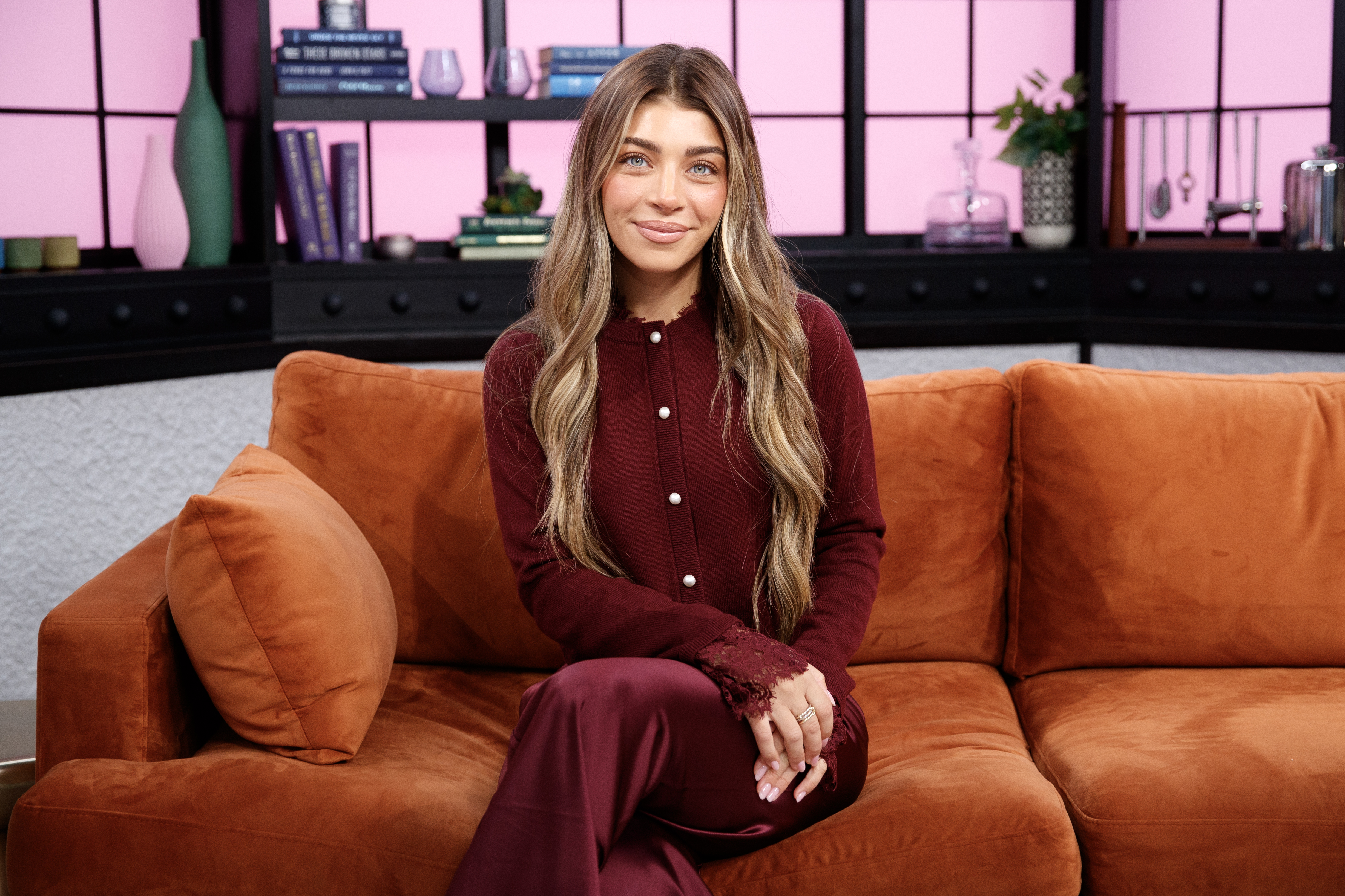 Gia Giudice seated on a couch during an interview.
