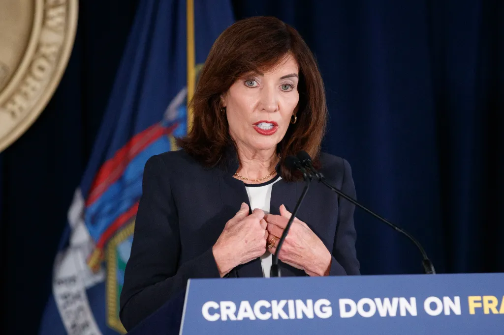 Governor Kathy Hochul speaking at a press conference regarding auto insurance fraud arrests.