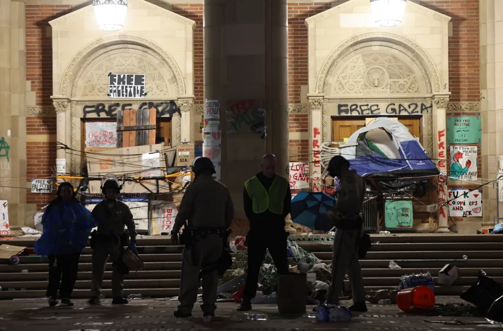 California Highway Patrol officers stand near a cleared pro-Palestinian encampment with graffiti-covered doors at UCLA.