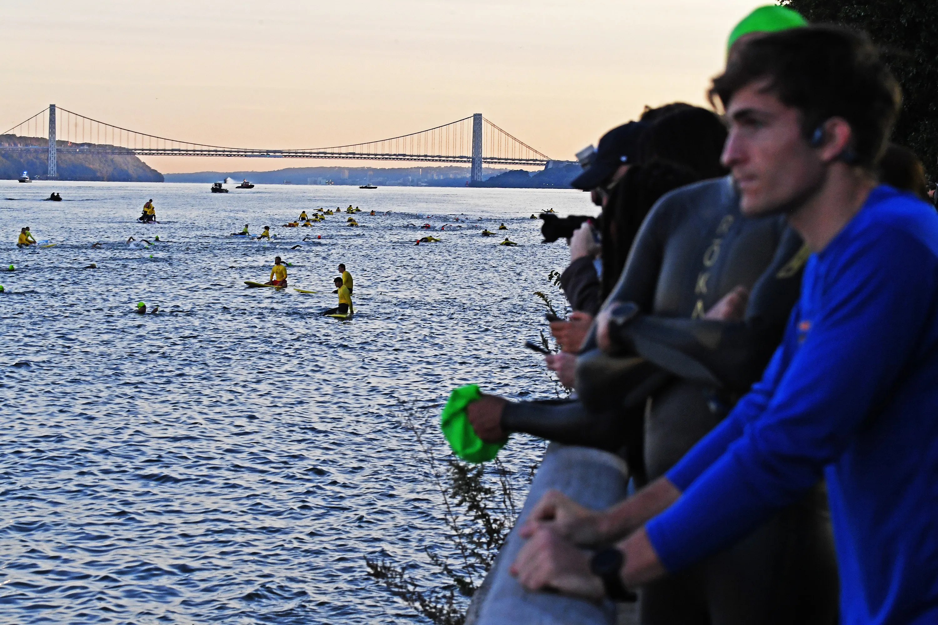 Competitors enter the Hudson River at the NYC Triathlon with the George Washington Bridge in the background.