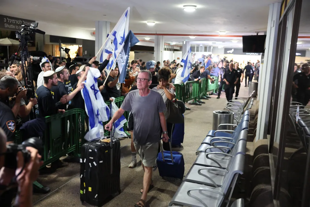 Passengers walk through the Ben Gurion International Airport after their mid-air diaster