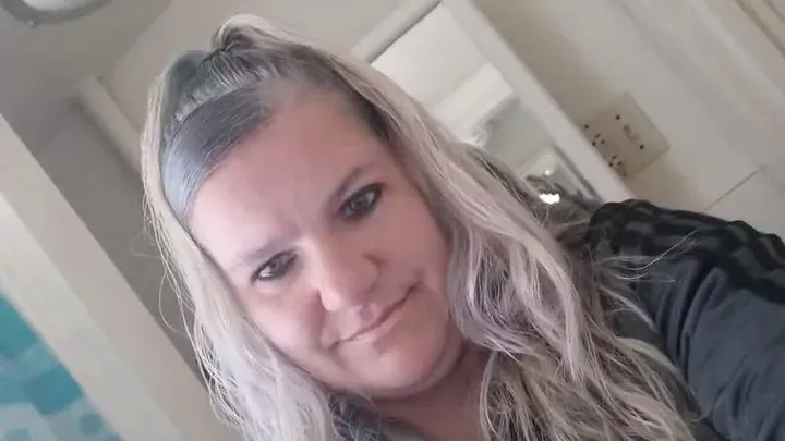 A selfie of a blonde woman with her hair half-up.