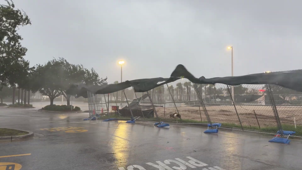Strong winds and rain lash a parking lot as Hurricane Isaias approaches.