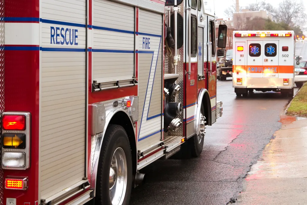 A fire truck and an ambulance parked on the side of a road.