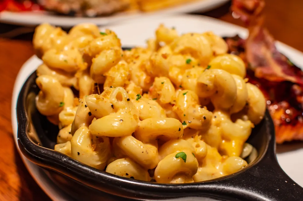 Creamy macaroni and cheese served in a small black pan.
