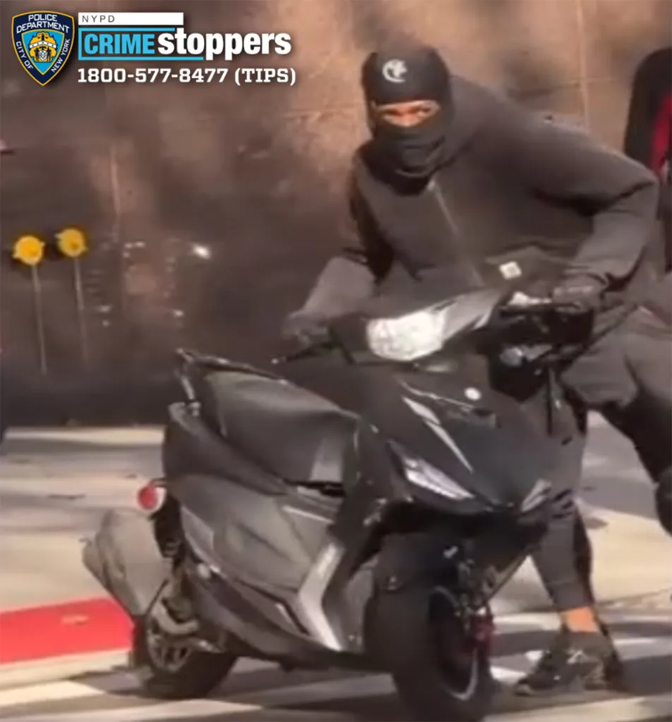 Surveillance image of a masked suspect on a moped.