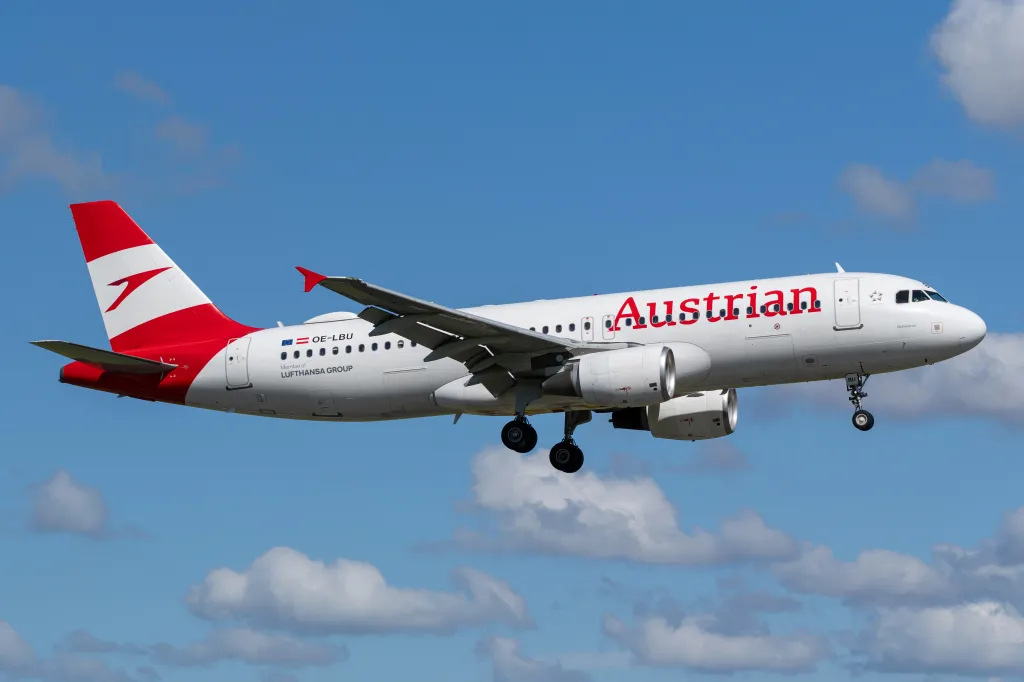 Austrian Airlines Airbus A320-200 with registration OE-LBU on approach for landing against a cloudy blue sky.