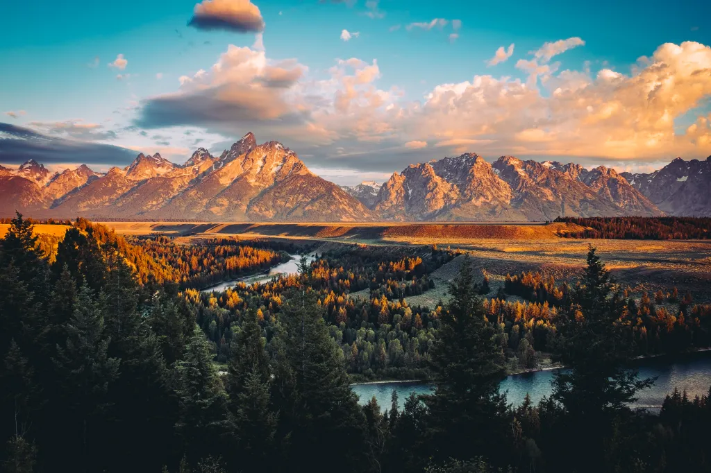 Grand Teton peaks at sunrise with the Snake River winding through the valley below in Wyoming, US.