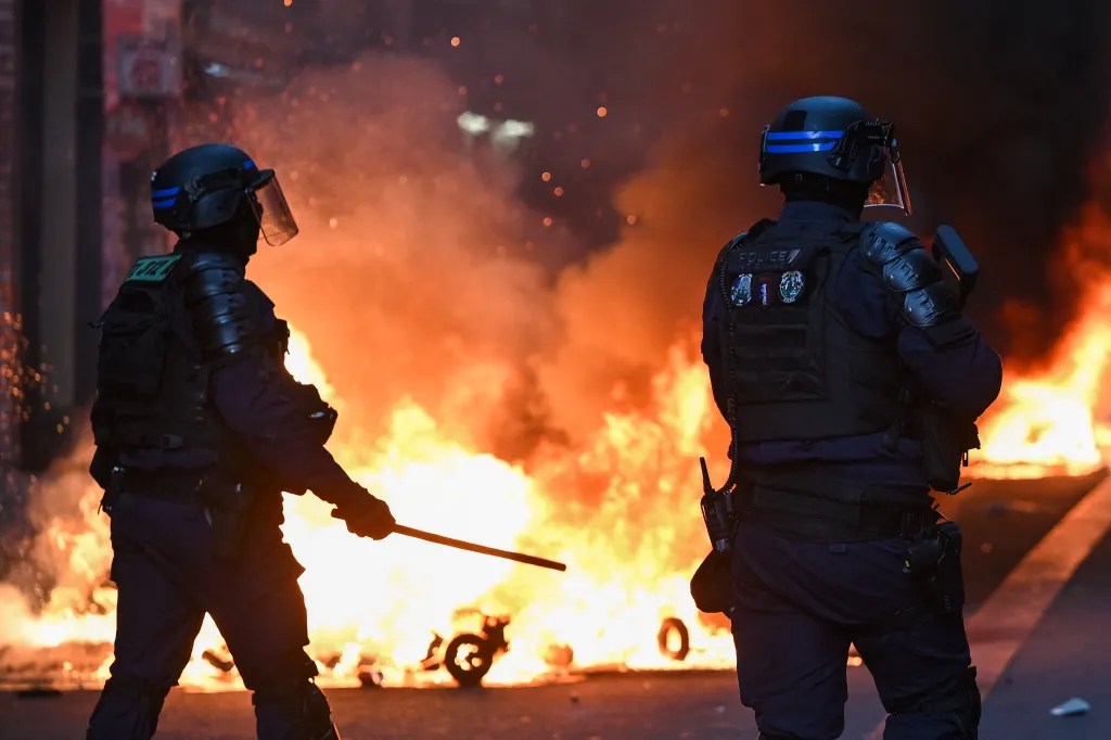 French Republican Security Corps officers stand in front of a street fire during clashes in Paris.