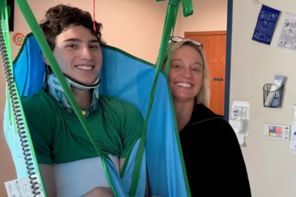 Wyatt Anderson smiling in a hospital lift sling next to a woman.