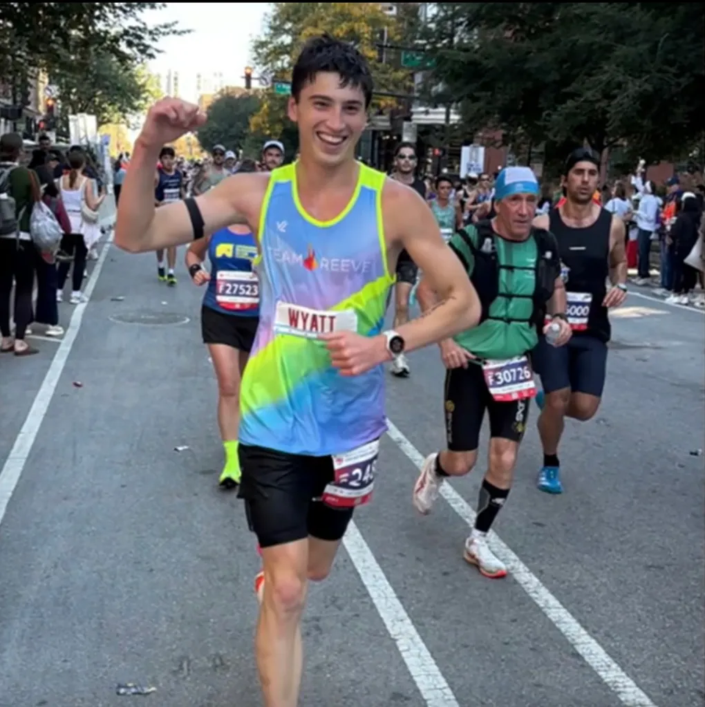 Wyatt Anderson, 17, smiles and raises his arm in celebration after finishing the Bank of America Chicago Marathon.