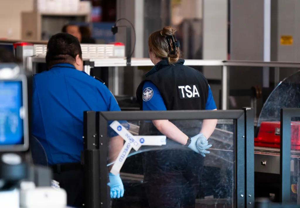 TSA agents watch travelers at Minneapolis-St. Paul International Airport.
