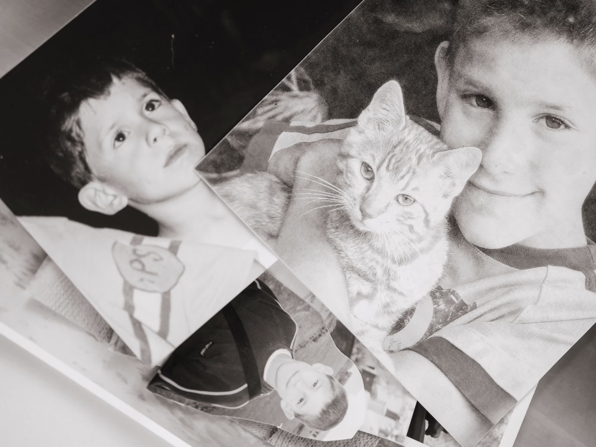 photo of stack of black-and-white photos of young boy, one with kitten