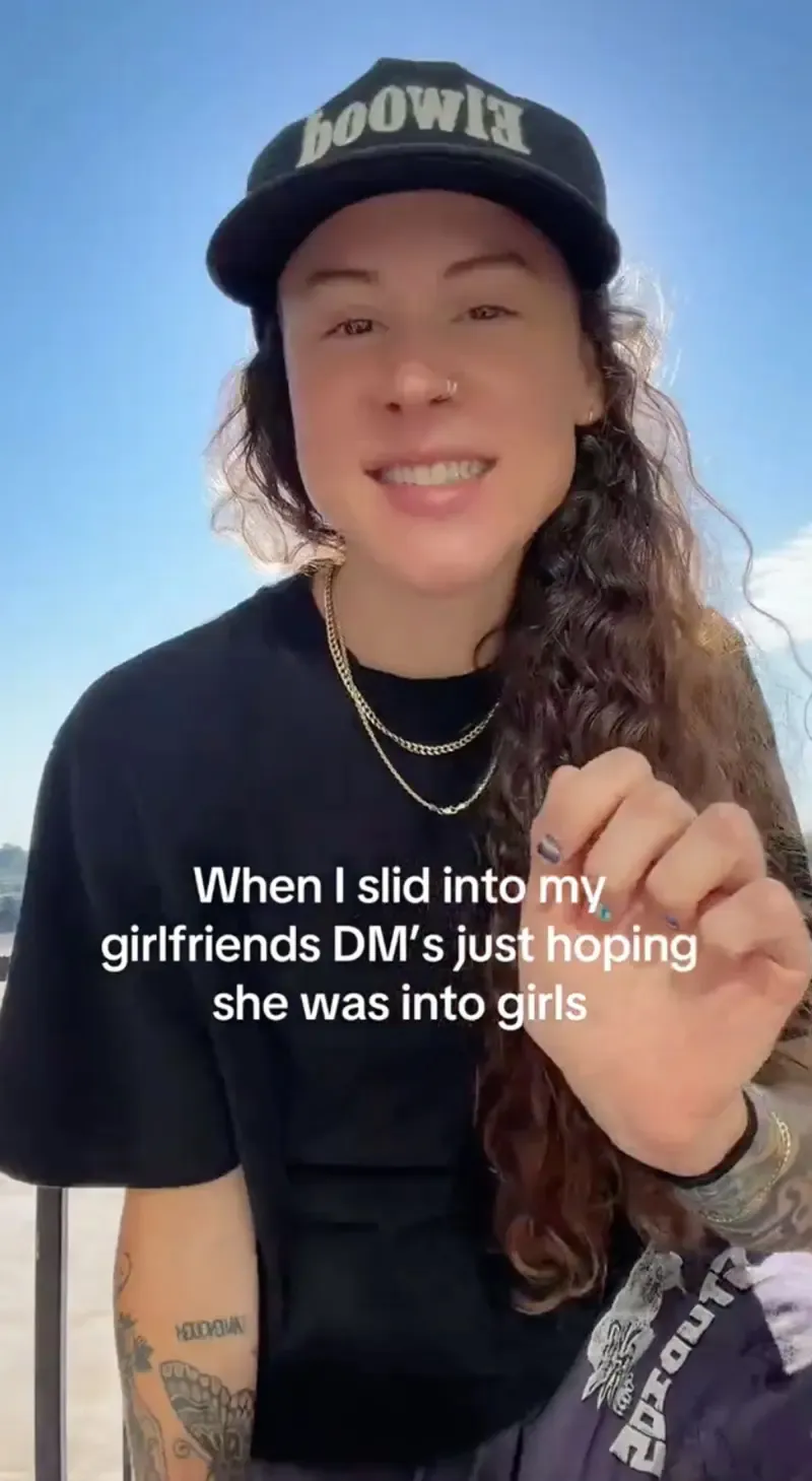 Chesser wearing a cap and black shirt, smiling while gesturing in a TikTok video.