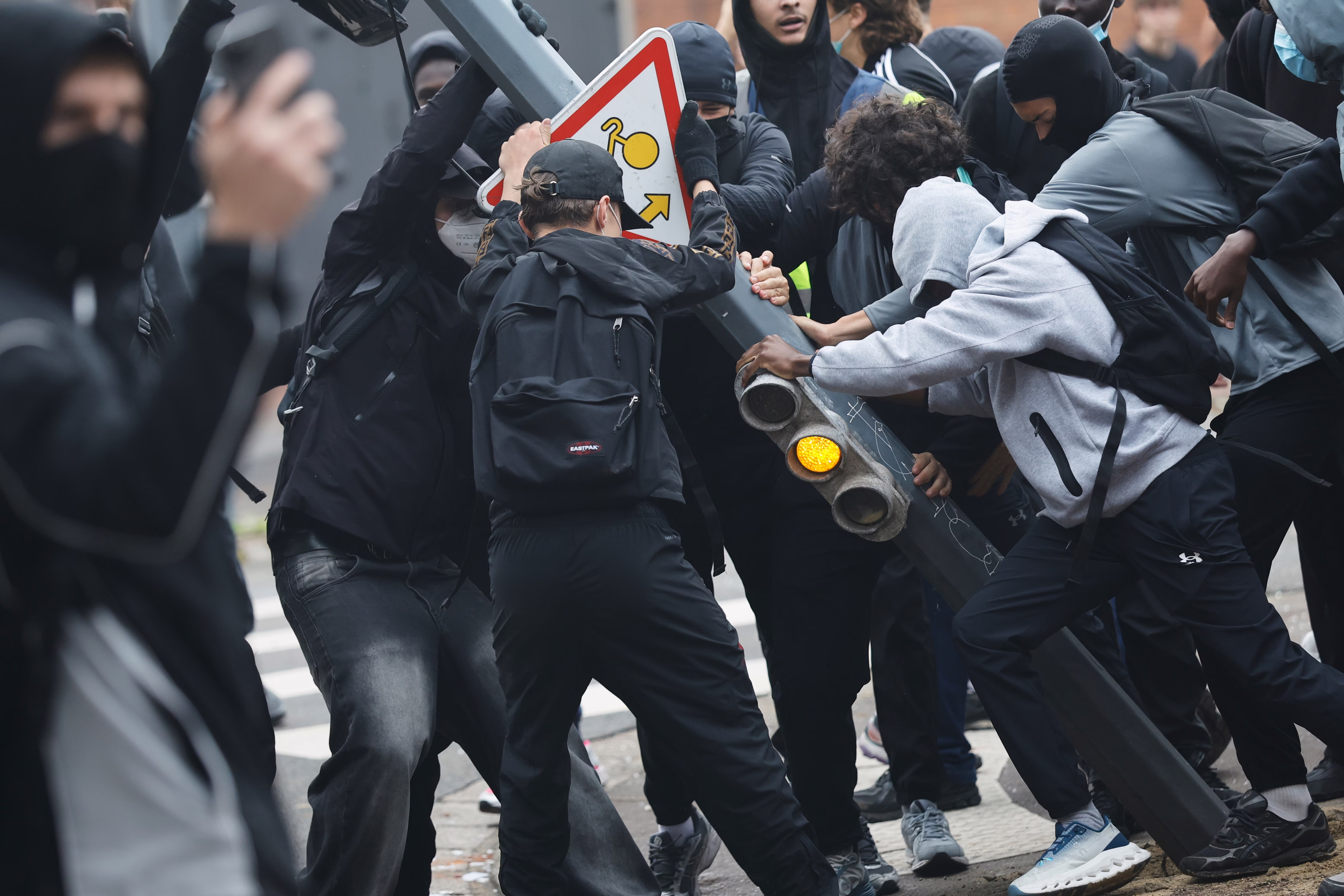 Students protesters tear down a traffic light.