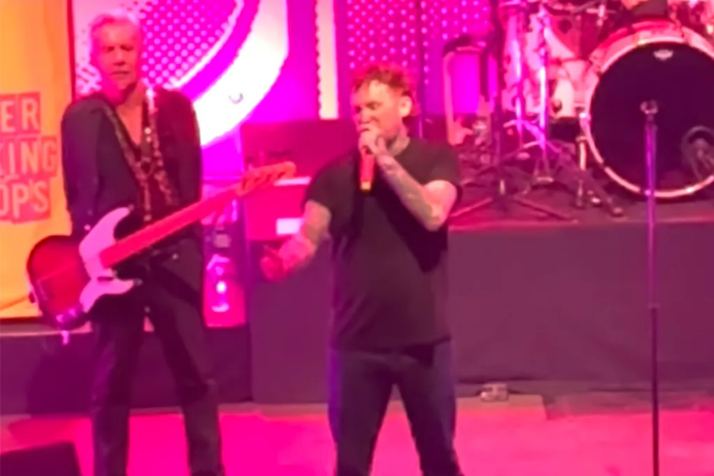 Sex Pistols frontman Frank Carter on stage with a band member holding a bass guitar.