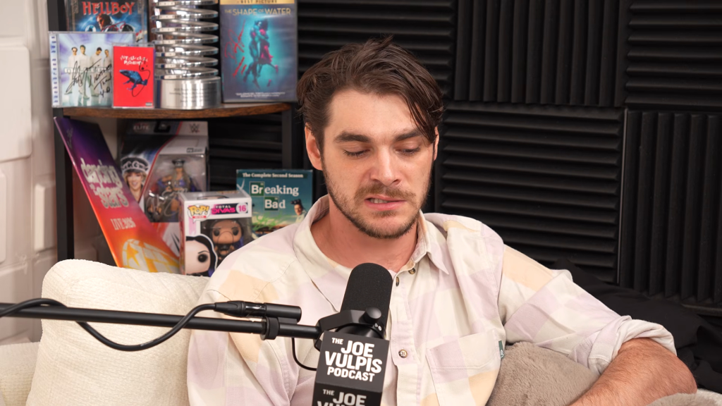 Actor RJ Mitte speaking into a microphone on a podcast.