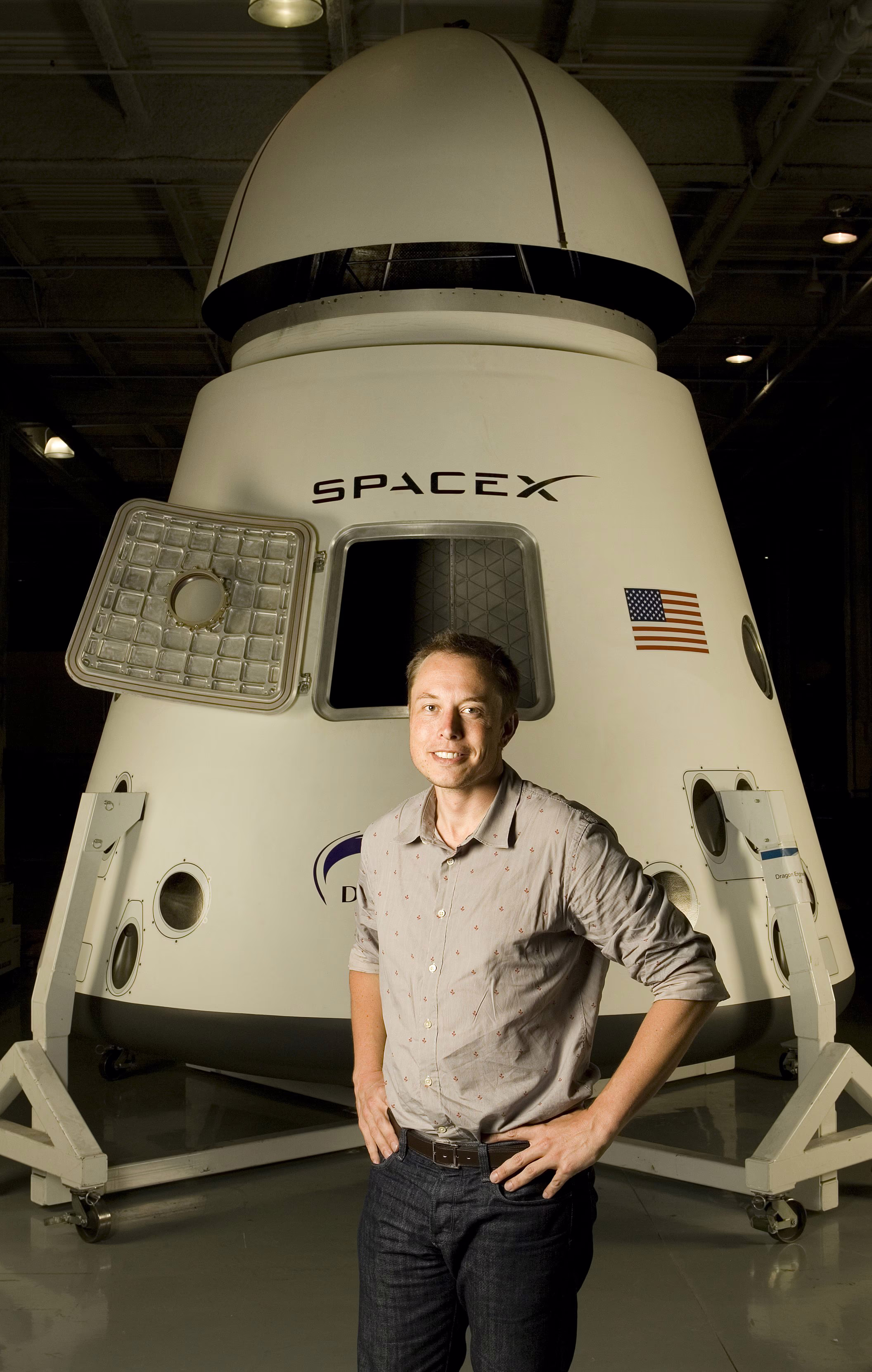 photo of young Elon Musk standing in front of SpaceX capsule with hatch open