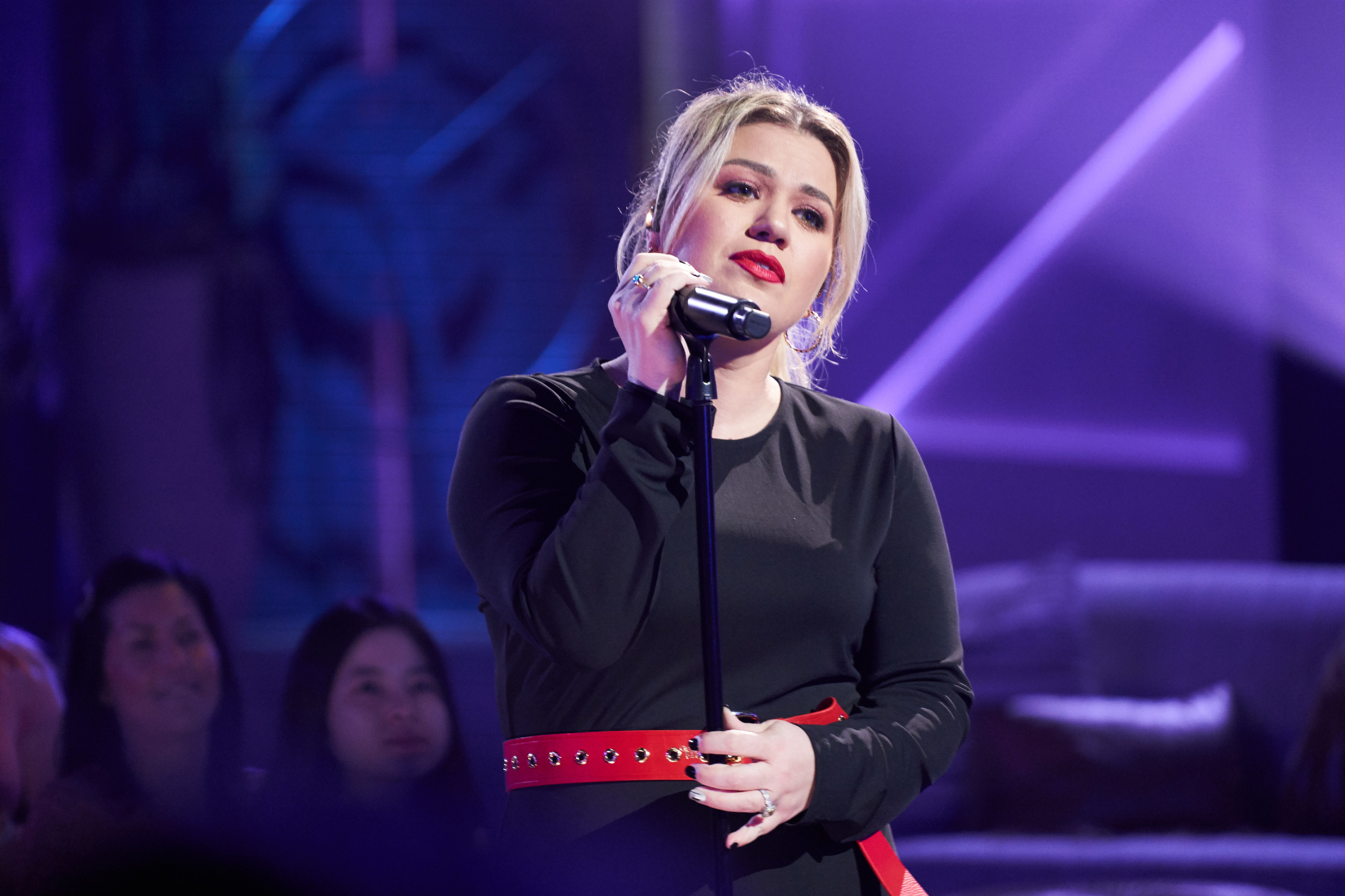 Kelly Clarkson sings into a microphone on The Kelly Clarkson Show.