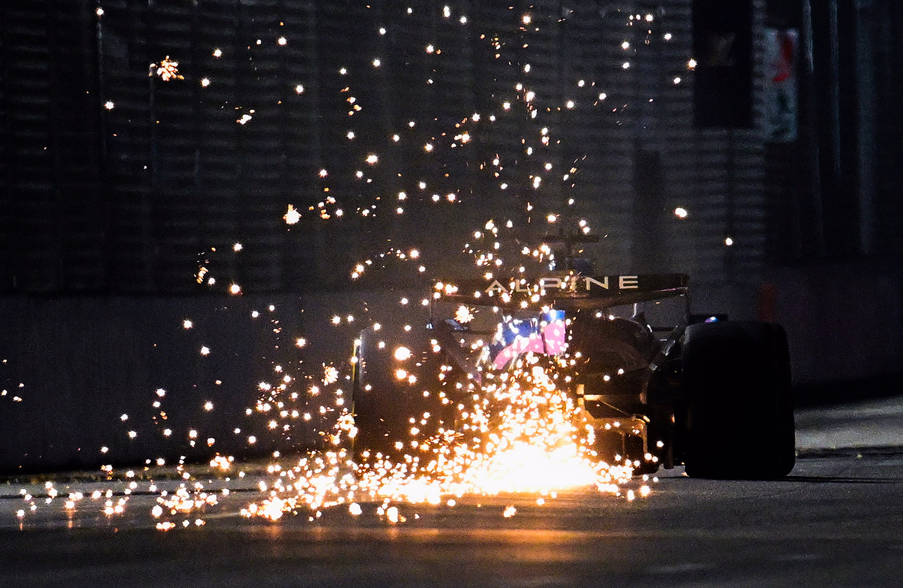 Sparks fly behind an F1 racing car.