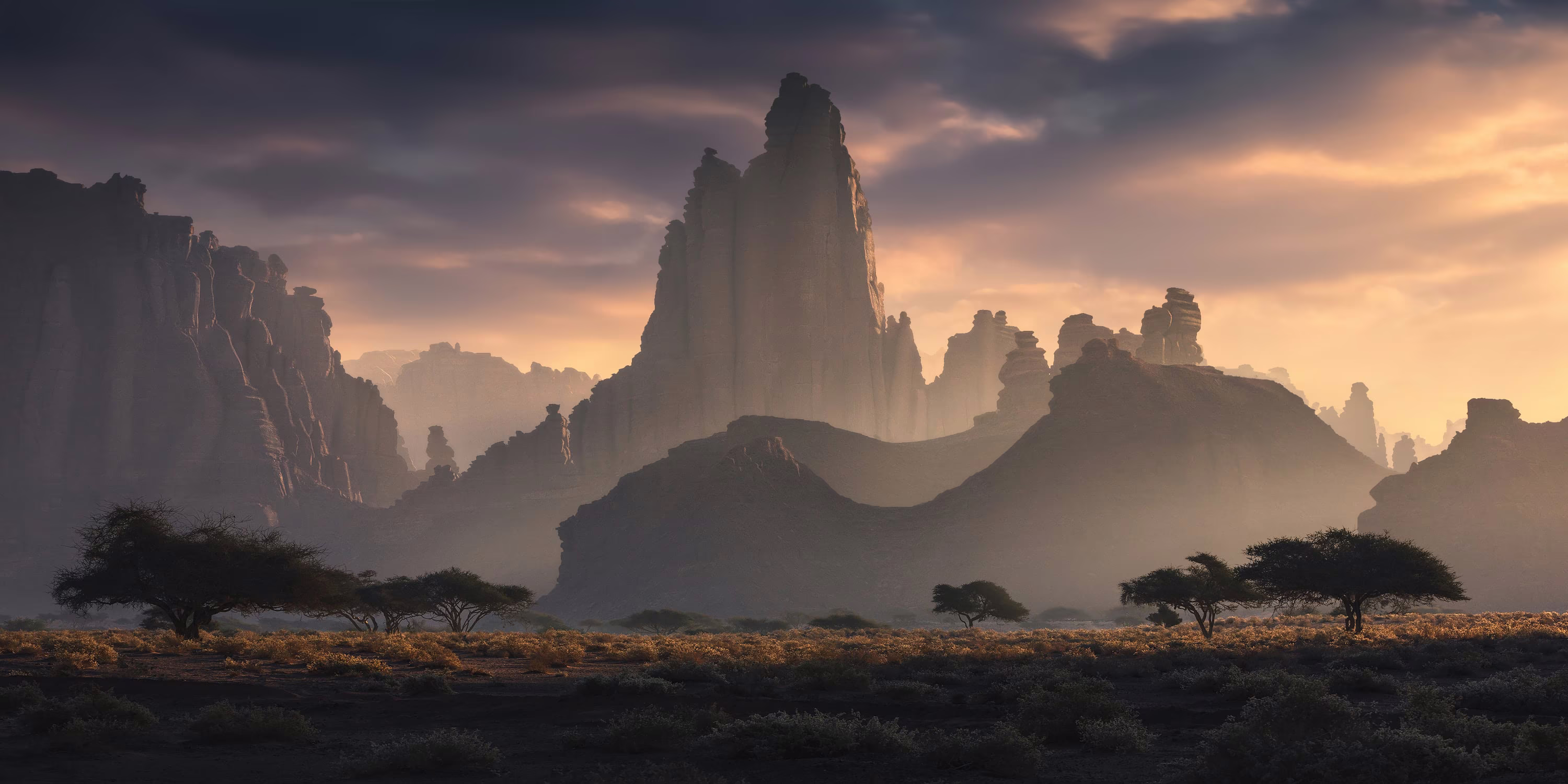 Tall cliffs and rock formations rise above a flat, arid landscape.