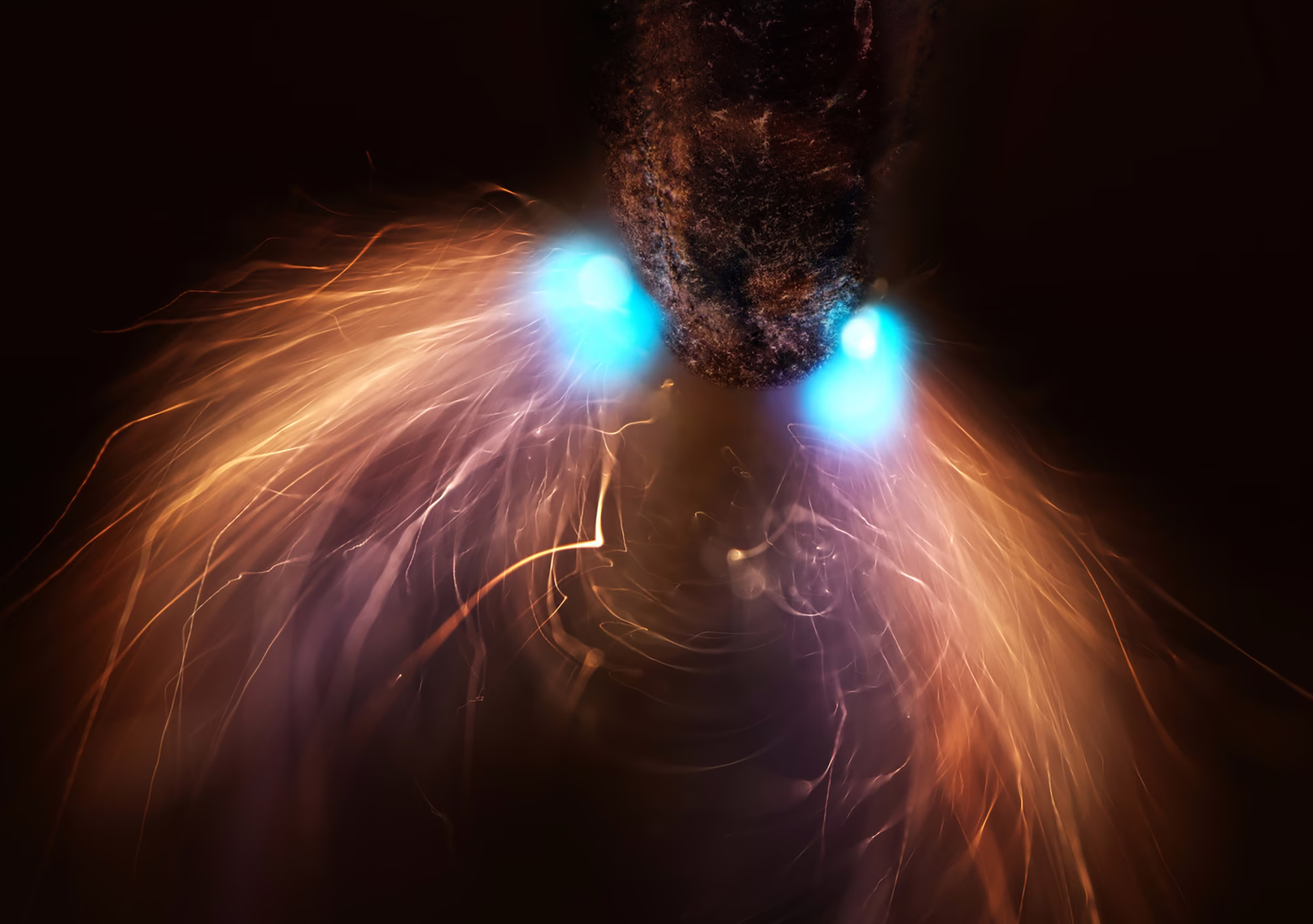 A very close view of the tip of a pencil being struck and illuminated by sparks