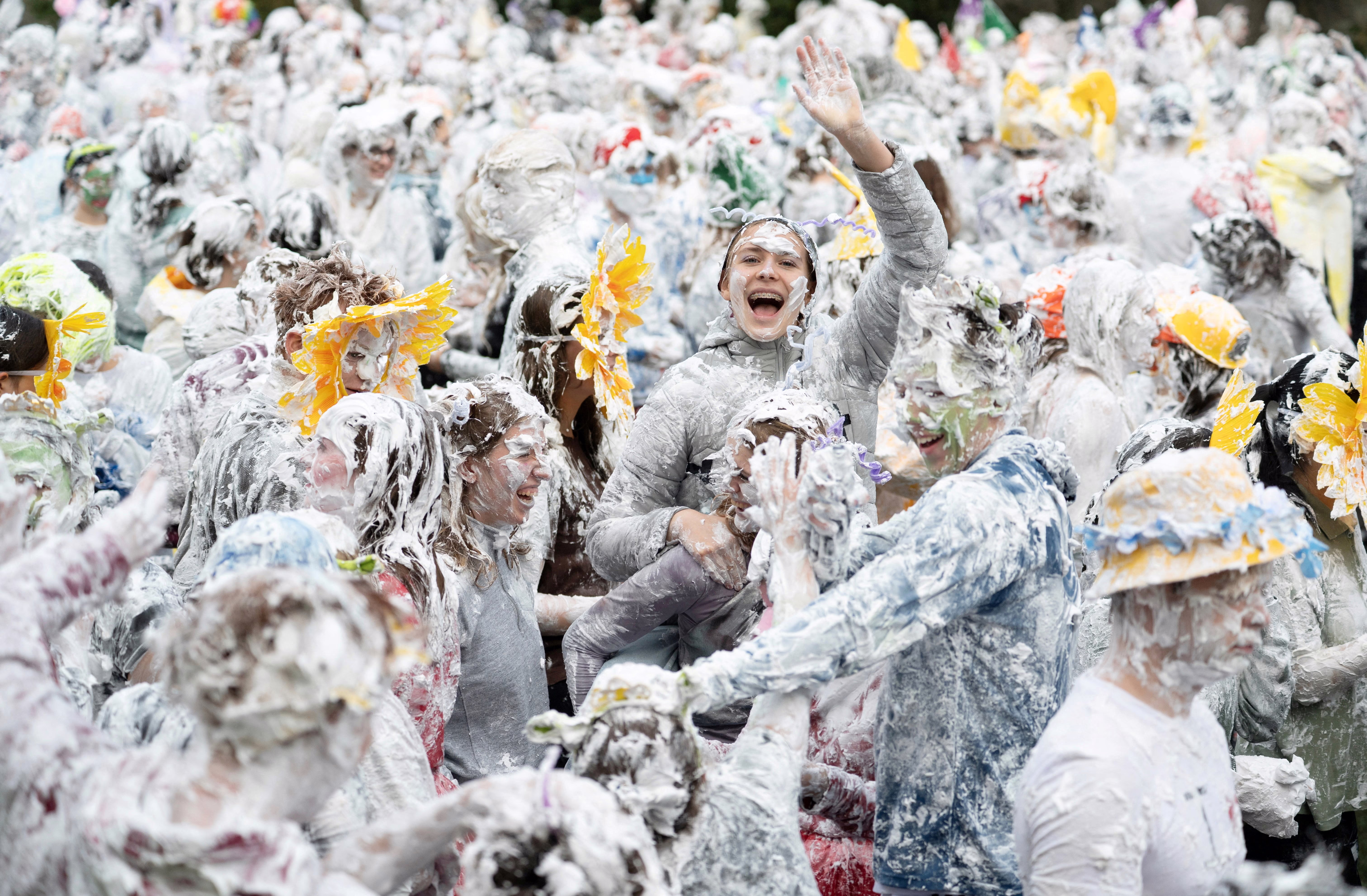A crowd of students, all covered from head-to-toe in soap suds