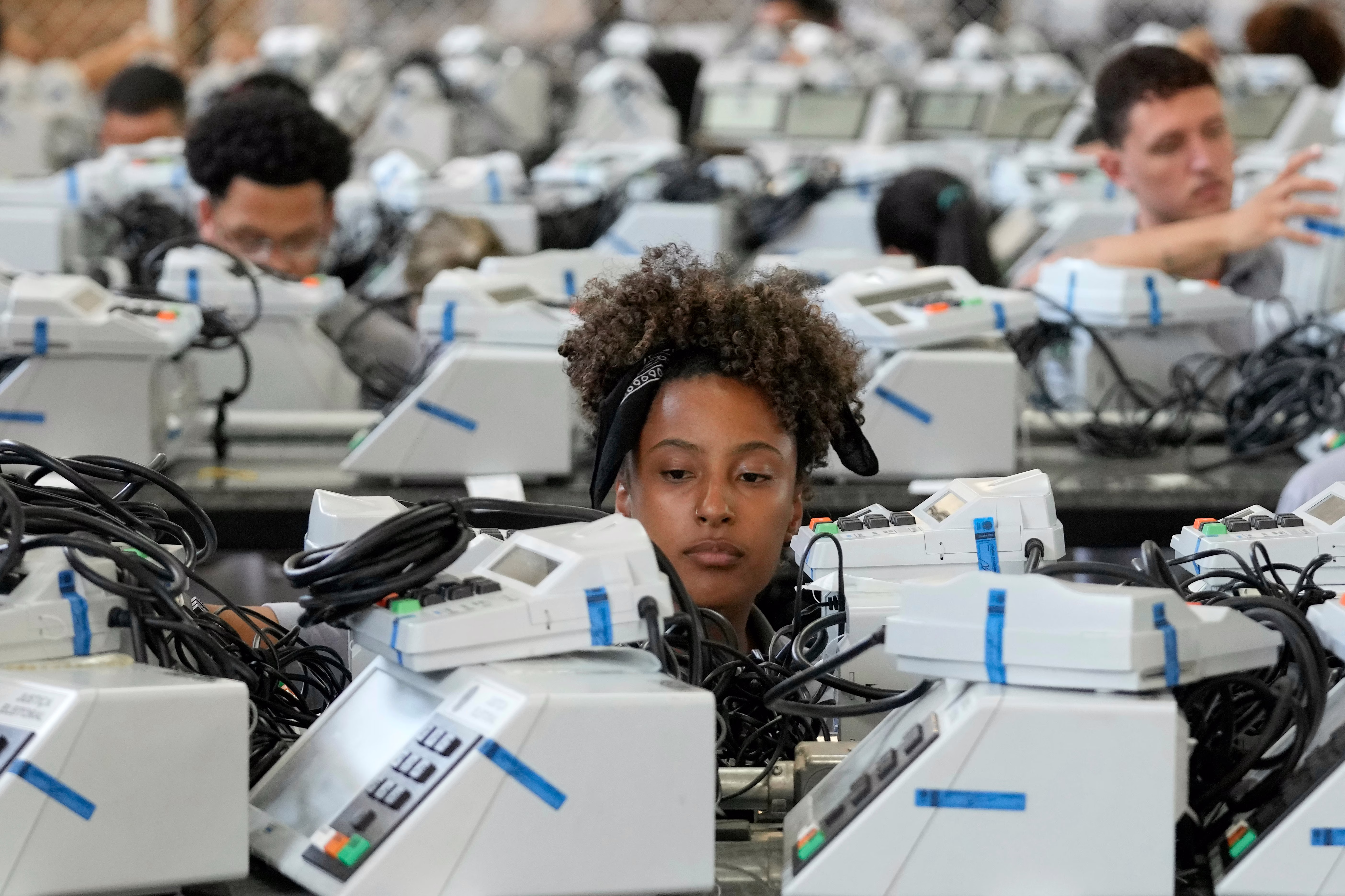 Electoral workers prepare electronic voting machines.