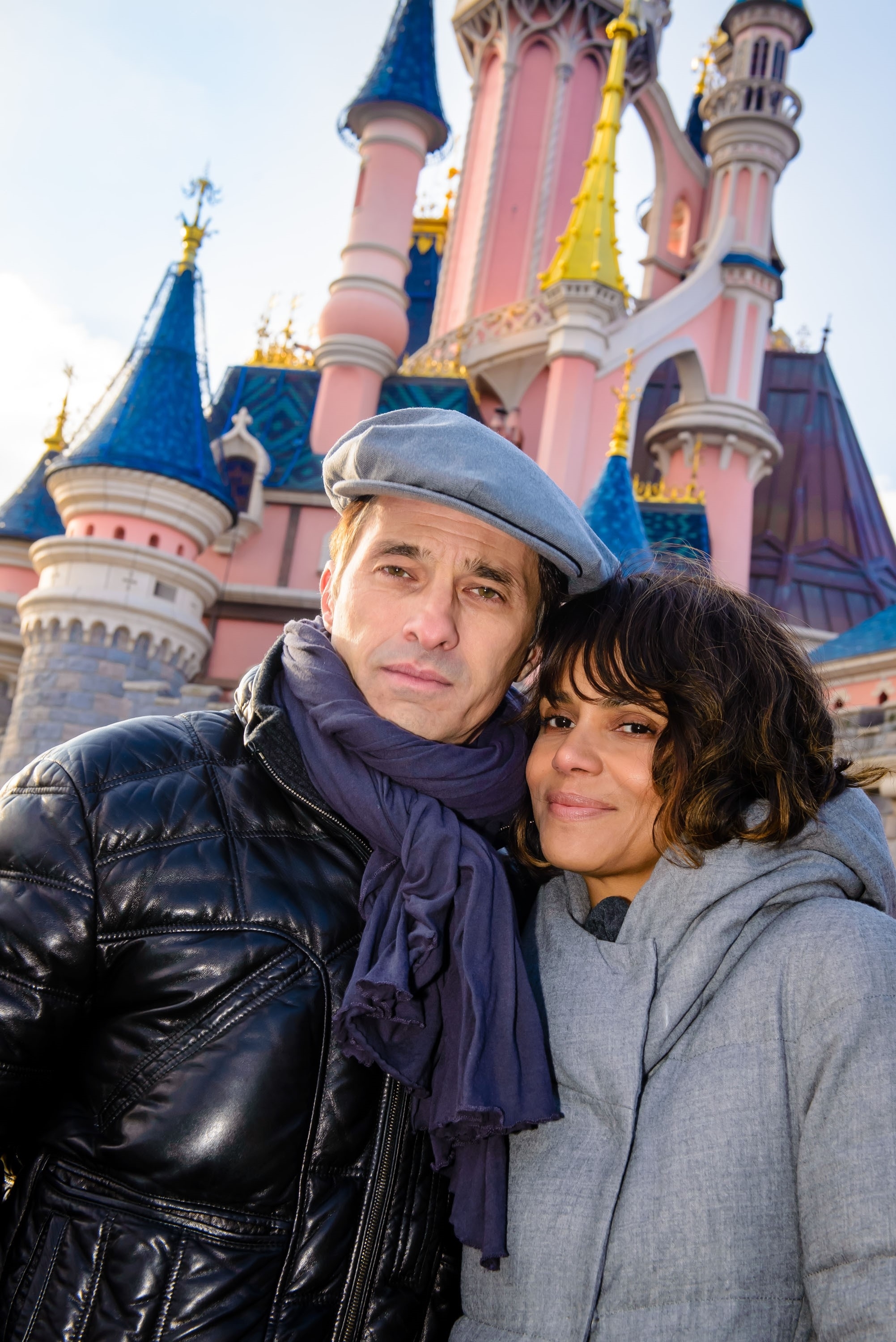 Halle Berry and Olivier Martinez pose in front of Sleeping Beauty Castle at Disneyland Paris.