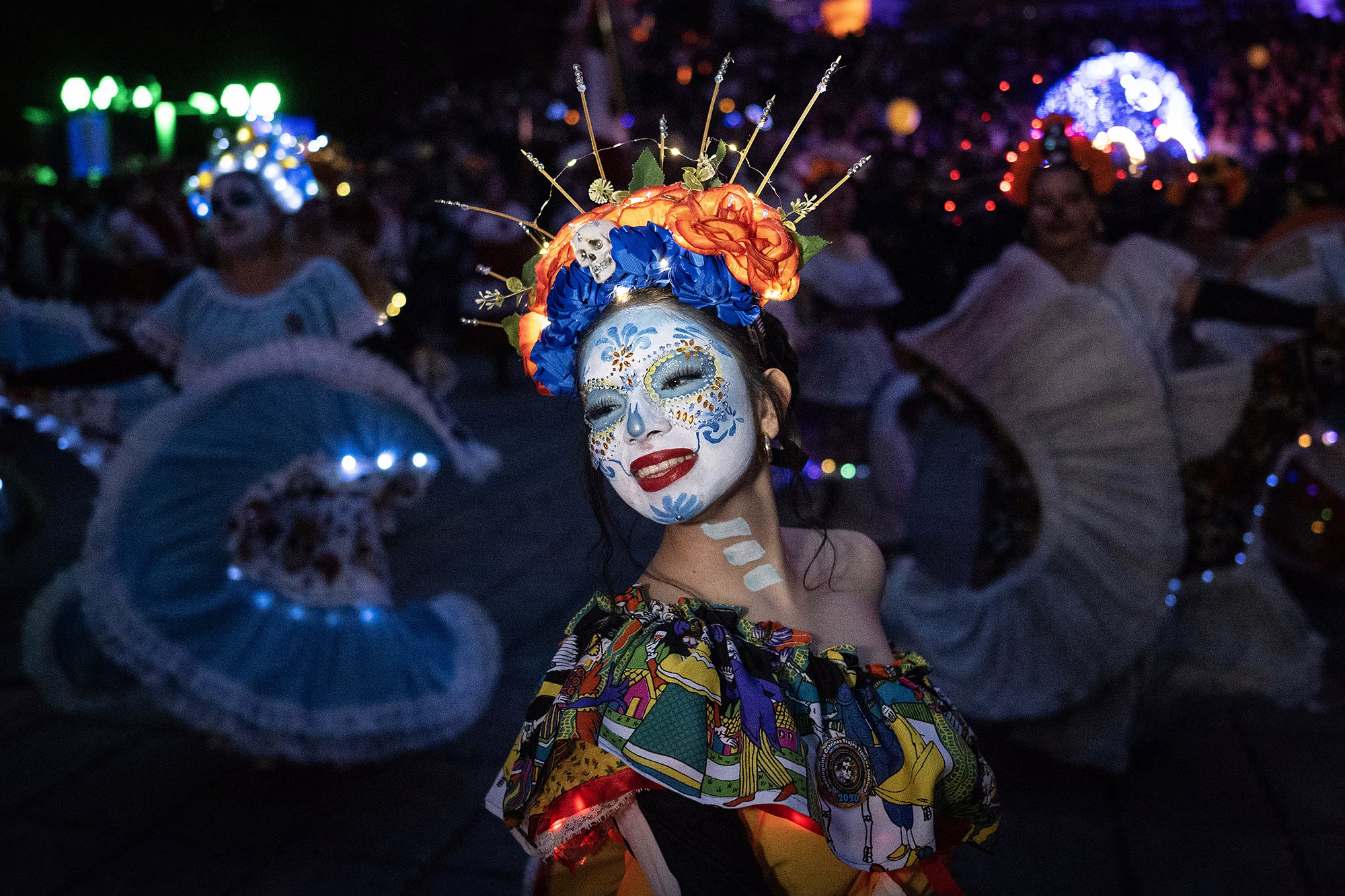 A woman dressed as a Catrina takes part in a parade.