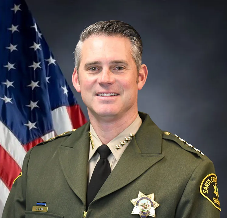 Sheriff Chris Clark in uniform with an American flag in the background.