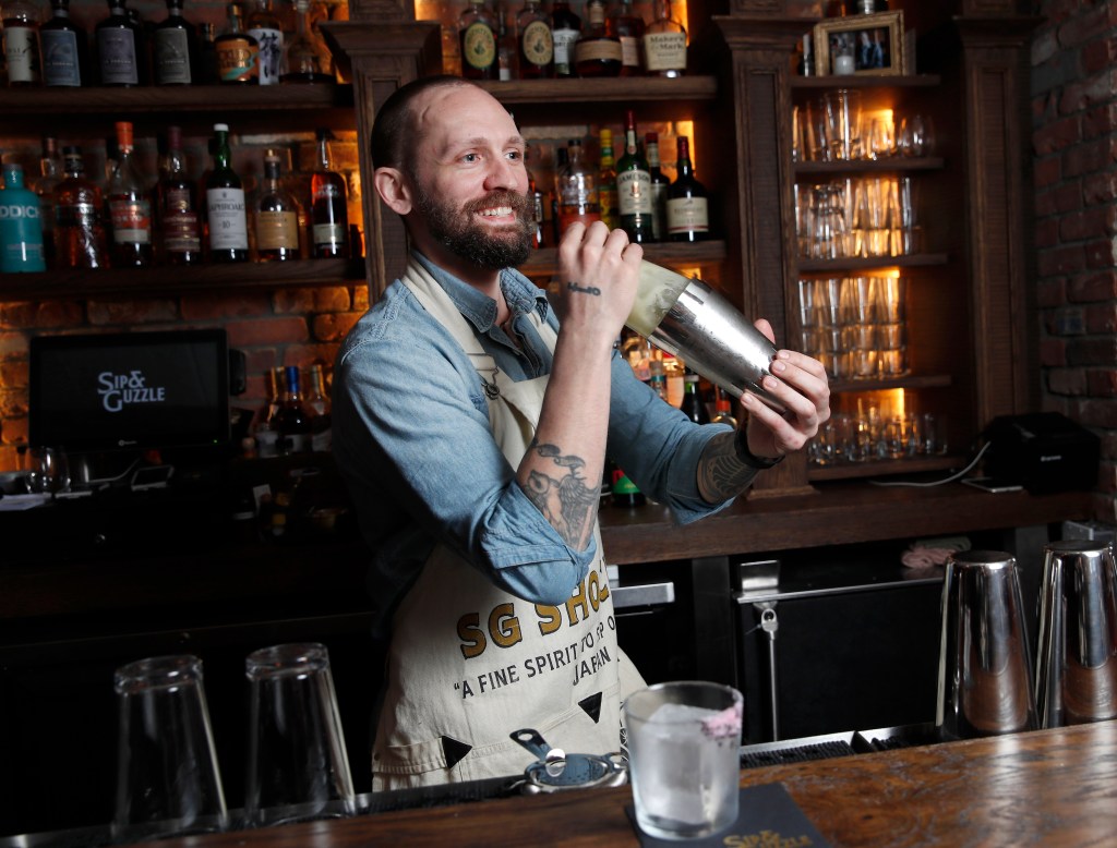 Steve Schneider shakes a cocktail at the Guzzle bar.